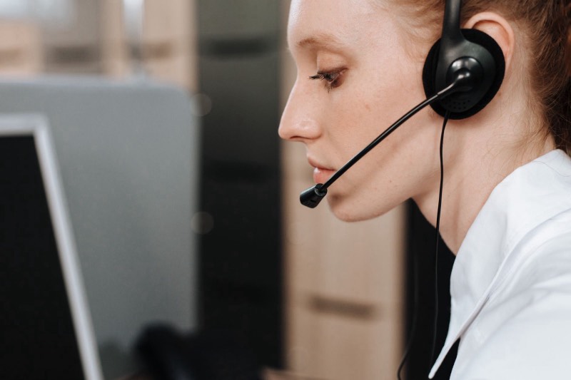 Femme de profil avec casque-micro en centre d'appels