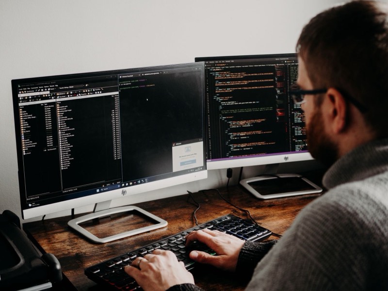 Développeur devant deux écrans remplis de code